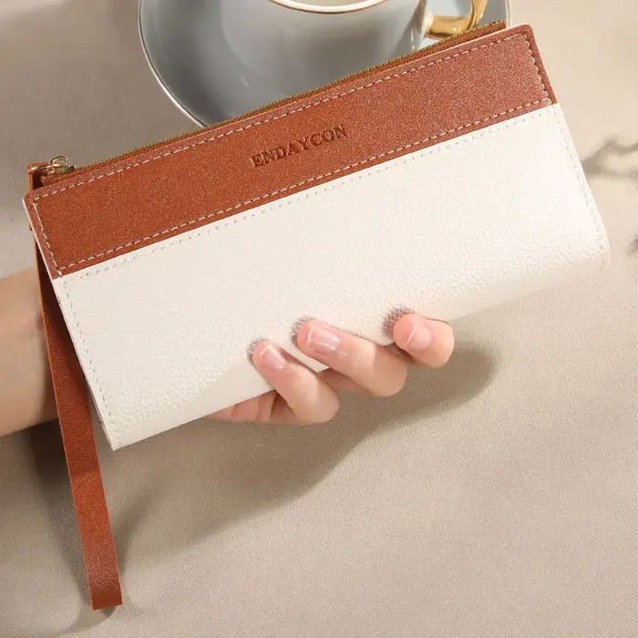 Portefeuille femme à la mode avec des couleurs contrastées ; long design à pompons ; porte-cartes multiples ; résout le