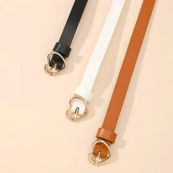 Un ensemble de trois ceintures fines à boucle dorée en forme de cœur